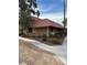 A tan one-story townhome with a red tile roof and mature trees at 2425 Paradise Village Way, Las Vegas, NV 89120