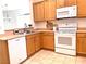Kitchen with light wood cabinets, white appliances, and tile flooring at 2575 Evening Twilight Ave, Henderson, NV 89044