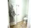 A toilet room with neutral tile flooring, a white toilet, and an open robe on the back of the door at 2575 Evening Twilight Ave, Henderson, NV 89044