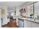 Charming kitchen with stainless steel dishwasher, sink and granite countertops extending into a living area at 3125 N Buffalo Dr # 1105, Las Vegas, NV 89128