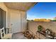 A cozy patio space featuring a door, a small table, and a view of trees at 3125 N Buffalo Dr # 1105, Las Vegas, NV 89128