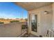 A cozy patio space featuring a door, a small table, and a view of trees and the street at 3125 N Buffalo Dr # 1105, Las Vegas, NV 89128