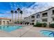 Relaxing pool area with lounge chairs, palm trees, and community buildings in the background at 3125 N Buffalo Dr # 1105, Las Vegas, NV 89128