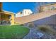 Spacious backyard featuring artificial grass, desert landscaping and a covered patio at 320 San Antonio River St, North Las Vegas, NV 89084
