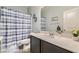 Bathroom featuring vanity with a single sink, mirror and shower with blue and white shower curtain at 320 San Antonio River St, North Las Vegas, NV 89084