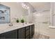 Bright bathroom with double sink vanity, framed mirror, modern lighting and glass enclosed shower stall at 320 San Antonio River St, North Las Vegas, NV 89084
