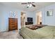 Comfortable bedroom features light blue walls, ceiling fan, dresser, and doorway views into bathroom and hallway at 320 San Antonio River St, North Las Vegas, NV 89084