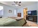 Bright bedroom features plush carpet, light blue walls, ceiling fan, TV, and a doorway view to the hallway at 320 San Antonio River St, North Las Vegas, NV 89084
