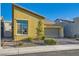 Charming yellow single-Gathering home with a well-maintained lawn and attached two-car garage at 320 San Antonio River St, North Las Vegas, NV 89084