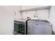 Convenient laundry room featuring front-load washer and dryer with shelving at 320 San Antonio River St, North Las Vegas, NV 89084