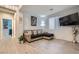 Spacious living room with wood tile floor, sectional sofa with pillows and window with blinds at 320 San Antonio River St, North Las Vegas, NV 89084