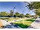 Outdoor bocce ball courts with artificial turf, shaded benches, and well-maintained landscaping under a clear blue sky at 3220 Flinthead Dr, North Las Vegas, NV 89084