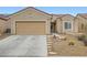 Inviting single-story home featuring desert landscaping, a two-car garage, and stone pathway at 3220 Flinthead Dr, North Las Vegas, NV 89084