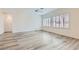 Bright, spacious living room featuring wood-look floors and plantation shutters on the windows at 3220 Flinthead Dr, North Las Vegas, NV 89084