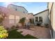 Paver patio with seating and grill, surrounded by lush landscaping and privacy wall at 3243 Fountaintree Ave, Henderson, NV 89044