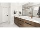 Bathroom with a double sink vanity, marble tile flooring, and a glass-enclosed shower at 3243 Fountaintree Ave, Henderson, NV 89044