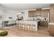 Modern kitchen featuring an island with seating, stainless steel appliances, and an open dining area at 3243 Fountaintree Ave, Henderson, NV 89044