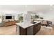 A modern kitchen and dining area feature an island, stainless steel appliances and wood floors at 3243 Fountaintree Ave, Henderson, NV 89044