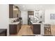 This kitchen has a center island, stainless steel appliances, stone countertops, and dark wood cabinets at 3243 Fountaintree Ave, Henderson, NV 89044