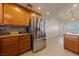 A spacious kitchen with stainless steel refrigerator and wood cabinets, flowing into a bright dining area at 3450 Oakleaf Ave, Pahrump, NV 89048