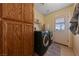 Functional laundry room with front loading machines, storage cabinets, and outside access at 3450 Oakleaf Ave, Pahrump, NV 89048