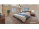 This staged main bedroom features a decorative rug, a ceiling fan and a king-sized bed with a wooden headboard at 3450 Oakleaf Ave, Pahrump, NV 89048