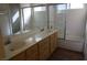 Well-lit bathroom featuring a dual sink vanity and a glass-enclosed shower and tub combo at 3745 Saint Peter Ct, North Las Vegas, NV 89031