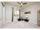 Spacious bedroom with a fan, large windows, and a small seating area at 3870 Valles Caldera Ct, Las Vegas, NV 89118