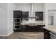 Gourmet kitchen with stainless steel appliances, granite countertops, dark wood cabinetry, and stylish range hood at 3870 Valles Caldera Ct, Las Vegas, NV 89118