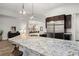 Expansive kitchen island boasts granite countertops, barstool seating, and modern pendant lighting fixtures at 3870 Valles Caldera Ct, Las Vegas, NV 89118