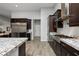 Gourmet kitchen with stainless steel appliances, granite countertops, dark wood cabinetry, and gas range at 3870 Valles Caldera Ct, Las Vegas, NV 89118