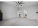 Bright main bedroom with neutral carpet, ceiling fan and multiple doors at 3870 Valles Caldera Ct, Las Vegas, NV 89118