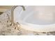 Close-up of tub featuring white basin, granite surround, and polished fixtures at 3870 Valles Caldera Ct, Las Vegas, NV 89118