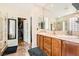 Elegant bathroom features dual sinks with wood cabinets, and a walk-in shower with glass doors at 4408 Oasis Hill Ave, North Las Vegas, NV 89085