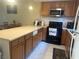Open kitchen with oak cabinets, modern appliances, and a breakfast bar at 4454 W Desert Inn Rd # B, Las Vegas, NV 89102