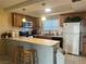 Traditional kitchen with breakfast bar, oak cabinets, and modern appliances at 4454 W Desert Inn Rd # B, Las Vegas, NV 89102