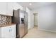 Kitchen area featuring stainless steel refrigerator, tile backsplash, white cabinets, and tile flooring at 4546 Regalo Bello St, Las Vegas, NV 89135