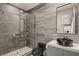 Modern bathroom featuring sleek gray tile, a glass-enclosed shower, and stylish black fixtures at 515 Serenity Point Dr, Henderson, NV 89012