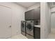 Efficient laundry room featuring modern washer/dryer units and storage cabinets at 515 Serenity Point Dr, Henderson, NV 89012