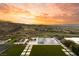 Backyard featuring infinity pool, lounge chairs, turf and sunset view overlooking the golf course and city at 515 Serenity Point Dr, Henderson, NV 89012