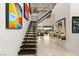 Grand foyer with floating staircase, modern art, and sleek design leading to a living area with city views at 515 Serenity Point Dr, Henderson, NV 89012