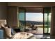 Scenic view from the bedroom through large glass doors to an outdoor seating area and distant mountains at 515 Serenity Point Dr, Henderson, NV 89012