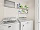Convenient laundry room equipped with a washer, dryer, and shelving for storage at 5448 Cove Point Dr, Las Vegas, NV 89130