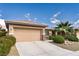 Inviting home exterior showcasing a two-car garage, desert landscaping, and a neatly kept front yard with palm tree at 5944 Saddle Horse Ave, Las Vegas, NV 89122