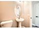 Charming powder room featuring a pedestal sink, oval mirror, and a toilet, providing a convenient space for guests at 6342 War Emblem Ct, Las Vegas, NV 89141