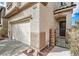 Close up of a two-car garage and gated entry to the front door of the two-story home at 6342 War Emblem Ct, Las Vegas, NV 89141