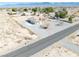 Aerial view of the single-story stucco home with extensive gravel landscaping and adjacent desert at 660 Indian Rd, Pahrump, NV 89048