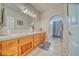 Well-lit bathroom featuring double sinks, wood cabinetry, and tile flooring at 660 Indian Rd, Pahrump, NV 89048