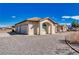 Single-story stucco home featuring an arched window, driveway, 3-car garage, and desert landscaping at 660 Indian Rd, Pahrump, NV 89048