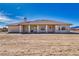 An open back patio with decorative supports runs along the back of the desert home at 660 Indian Rd, Pahrump, NV 89048